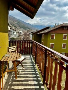 een houten balkon met een houten tafel en een bank bij Alpine Escape 3 in Bormio