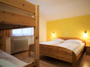 ein Schlafzimmer mit 2 Etagenbetten und einer gelben Wand in der Unterkunft Berghof Burtscher in Ludesch