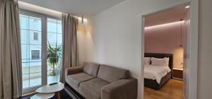 ein Schlafzimmer mit einem Sofa, einem Bett und einem Fenster in der Unterkunft TAM Serviced Apartment City Center No3 in Tirana