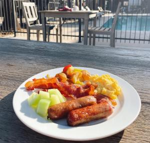 a plate of food with sausage potatoes and apples at Four Points by Sheraton San Rafael Marin County in San Rafael
