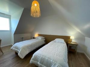 um quarto com 2 camas e um lustre em Résidence L-tregastel - Maisons & Villas 374 em Trégastel