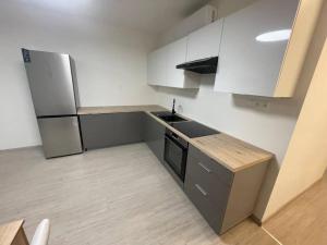 a kitchen with white cabinets and a refrigerator at Big 3-bedroom apartment 78m² in Bratislava