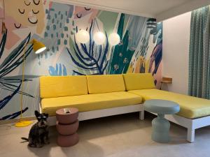 a yellow couch in a living room with a dog at Aparthotel Boutique Poniente Playa in San Antonio