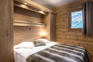a bedroom with a large bed with a window at Résidence LA GRANGE AUX FEES - Appartement GRANGE AUX FEES E04 pour 8 Personnes in Valmorel