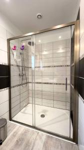 La salle de bains est pourvue d'une douche avec une porte en verre. dans l'établissement Résidence D-pleumeur Bodou - Maisons & Villas 314, à Pleumeur-Bodou