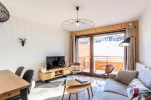 a living room with a couch and a table at Résidence LODGES 1970 - Appartement LODGES A402 pour 6 Personnes 14 in La Plagne