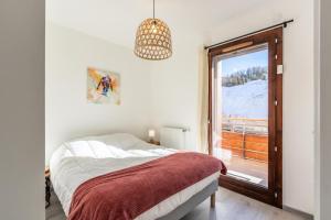 a white bedroom with a bed and a window at Résidence LODGES 1970 - Appartement LODGES A402 pour 6 Personnes 14 in La Plagne