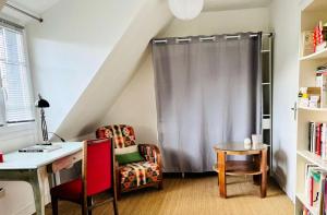 トレガステルにあるRésidence G40-tregastel - Ker Glen ambiance calme et cosy près de la mer MAE-5894のデスク、椅子、カーテンが備わる客室です。