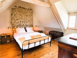 a bedroom with a bed and a stone wall at Résidence D02-tregastel - Vacances près de la mer dans une maison médiévale MAE-4284 in Trégastel