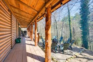 um alpendre de uma cabana de madeira com cadeiras e mesas em Stunning Georgia Cabin with Private Hot Tub and Views em Tiger