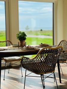 uma sala de jantar com uma mesa e cadeiras e uma janela em Saaremaa majake mere ääres em Torgu