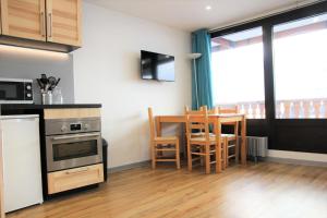 a kitchen and dining room with a table and chairs at Résidence Neves - VAL THORENS location: Studio ensoleillé pour 4 personnes dans un quartier animé (LES NEVES) MAE-9081 in Val Thorens