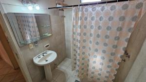 a bathroom with a sink and a shower curtain at SOCRA Centro in Asuncion