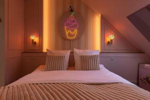 - une chambre dotée d'un grand lit avec un petit gâteau au mur dans l'établissement Le Milkshake - Hypercentre, Cinéma, King size, à Troyes