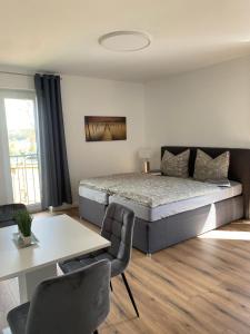 a bedroom with a bed and a table and chairs at Bruchersee 4 oberbergisches Land in Marienheide