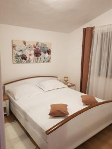 a white bed in a bedroom with a picture on the wall at Holiday Home Nada in Sali