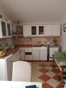 a kitchen with white cabinets and a tile floor at Holiday Home Nada in Sali