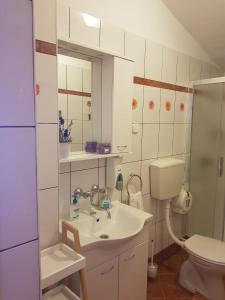 La salle de bains est pourvue d'un lavabo, de toilettes et d'un miroir. dans l'établissement Holiday Home Nada, à Sali