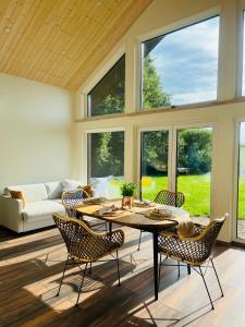 - un salon avec une table, des chaises et des fenêtres dans l'établissement Saaremaa majake mere ääres, à Torgu