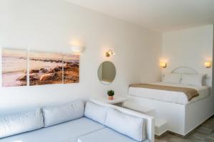 a living room with a bed and a couch at Enalion White Suites Oia in Oia