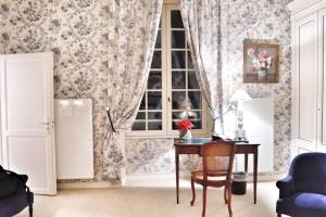 Cette chambre comprend une table, une fenêtre et une chaise. dans l'établissement Chateau Sénailhac, à Tresses