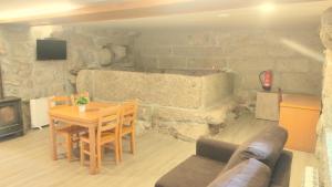 sala de estar con mesa y pared de piedra en Casa da Lagiela rural senses, en Fafe