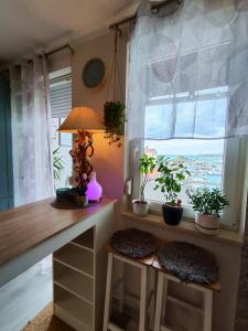um quarto com uma secretária com vasos de plantas e uma janela em My happy place em Poreč