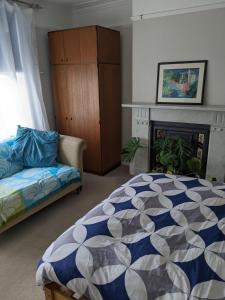 1 dormitorio con cama, sofá y chimenea en Comfort and Convenience double with ensuite London W7 en Londres