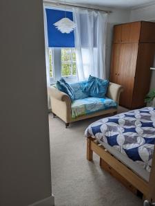 a bedroom with a bed and a couch and a window at Comfort and Convenience double with ensuite London W7 in London