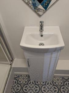 - Baño con lavabo blanco y suelo de baldosa en Comfort and Convenience double with ensuite London W7 en Londres
