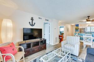 a living room with a tv and a couch and chairs at Carolina Beach Condo with Balcony and Ocean Access! in Carolina Beach