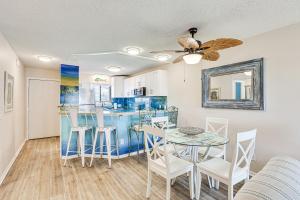a dining room and kitchen with a table and chairs at Carolina Beach Condo with Balcony and Ocean Access! in Carolina Beach