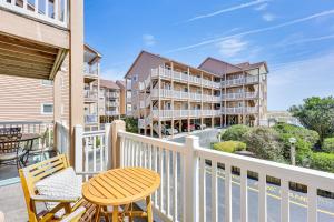 a balcony with a table and chairs and condos at Carolina Beach Condo with Balcony and Ocean Access! in Carolina Beach