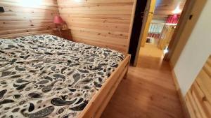a bedroom with a bed with a black and white comforter at MUCILLON G - Appartement MUCILLON 794 in Valmorel