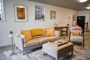 sala de estar con sofá y silla en Marys Gatehouse Garden Apartment, en Greensboro