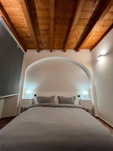 1 dormitorio con 1 cama blanca grande y 2 mesitas de noche en LA VOLTA - ANTESITUM - historic, on the lake, en Malgrate