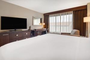 a hotel room with a bed and a flat screen tv at Crowne Plaza Auburn Hills, an IHG Hotel in Auburn Hills