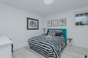 a bedroom with a bed with a black and white comforter at Marys Gatehouse Garden Apartment in Greensboro