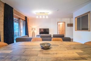 een woonkamer met een houten tafel en stoelen bij Résidence LUMI BATIMENT B - Appartement LUMI B pour 4 Personnes 014 in Valmorel