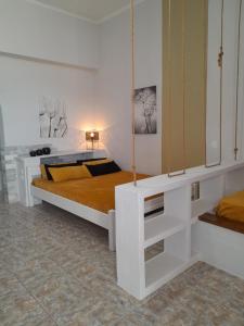 ein weißes Schlafzimmer mit einem Bett und einem Spiegel in der Unterkunft Overhill Apartments Adamas in Adamas