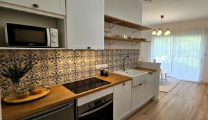 cocina con fregadero y microondas en Appartement Le Porto en Cholet