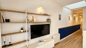 uma sala de estar com uma grande televisão de ecrã plano em Appartement Le Porto em Cholet