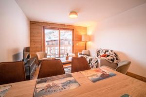 a living room with a table and chairs at Résidence LUMI BATIMENT B - Appartement LUMI B pour 7 Personnes 224 in Valmorel