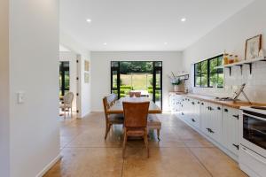 een keuken met witte kasten en een tafel en stoelen bij Sierra Sky Manor located in Countryside in Dairy Flat