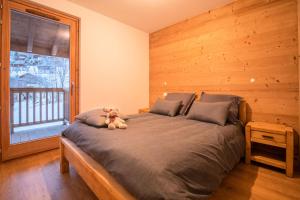 a teddy bear sitting on a bed in a bedroom at Résidence LUMI BATIMENT B - Appartement LUMI B pour 4 Personnes 004 in Valmorel