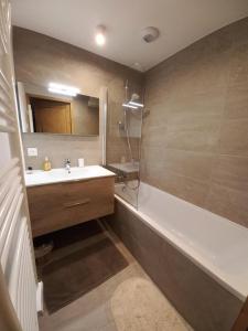 a bathroom with a tub and a sink and a bath tub at Résidence LUMI BATIMENT B - Appartement LUMI B 834 in Valmorel