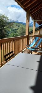 two blue chairs on a porch with a view of the mountains at Résidence LUMI BATIMENT B - Appartement LUMI B 834 in Valmorel