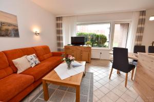ein Wohnzimmer mit einer Couch und einem Tisch in der Unterkunft Haus "Luv und Lee" Appartement LEE02 in Döse