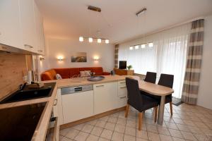 eine Küche und ein Wohnzimmer mit Tisch und Stühlen in der Unterkunft Haus "Luv und Lee" Appartement LEE02 in Döse