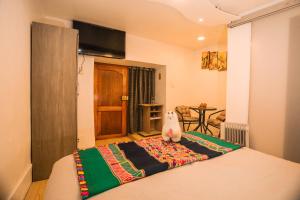 a bedroom with a bed with a stuffed animal on it at RumiUma Boutique Hotel in Cusco